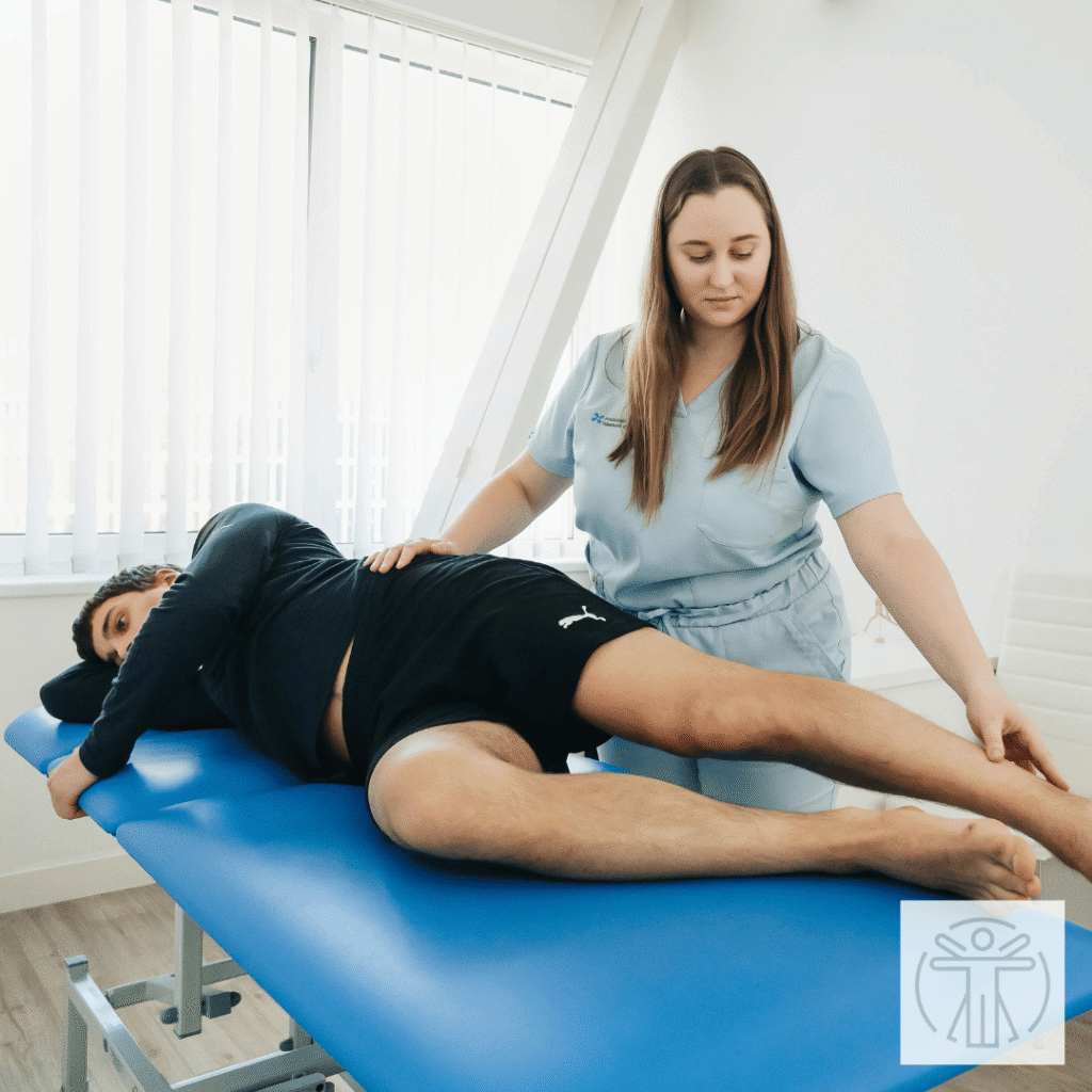 therapist guiding a woman through a stretch on a treatment table